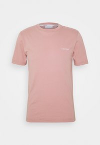 Světle růžové bavlněné tričko s krátkým rukávem, kulatým výstřihem a malým bílým logem na levé hrudi. Hladká textura, ležérní design.