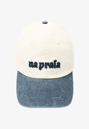 Baseballkappe mit cremefarbener Krone, blauem Denim-Schirm und dunkelblau besticktem Text „na praia“ auf dem Frontpaneel.