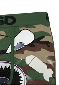 Boxers ajustados de camuflaje verde con una cinturilla negra, que presentan impresiones gráficas de una boca de tiburón y iconos de temática militar en blanco y gris.