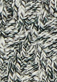 Tessuto a maglia nei toni del nero, bianco e grigio, caratterizzato da un motivo testurizzato a zigzag con fibre attorcigliate che creano profondità e dimensione.