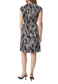 Schwarz-weiß gemustertes Kleid mit kurzen Ärmeln, tailliertem Schnitt und knielangem Saum. Glattes Material mit vertikalen Streifenmuster.