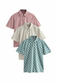 Trois polos : un rose pâle, un crème avec un motif de feuilles, et un teal avec un design géométrique de feuilles, tous présentant un col.