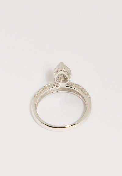 Ασημένιο δαχτυλίδι αρραβώνων με καρδιόσχημη βάση που κρατά ένα μικρό σύμπλεγμα διαμαντιών σε λευκό φόντο.