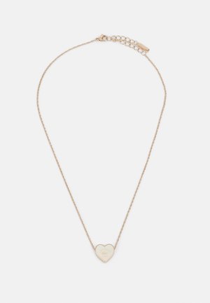 Guldfarvet kædetrøje med en hjerteformet vedhæng med en graveret logo. Delikat design og teksturerede led med en krabbe-lås.