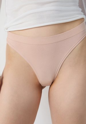 Light pink thong underwear with a soft, seamless waistband, made from a smooth cotton blend fabric, featuring a minimalist design.