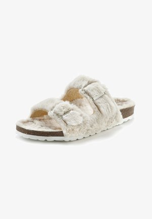 Faux-Fell-Slidesandal in Creme mit zwei verstellbaren Riemen, Kork-Mittelsohle und weißer Gummisohle. Weiche Textur, offenes Zehendesign.