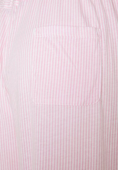 Tissu rayé rose et blanc avec une poche plaquée. Le tissu semble léger et doux avec des rayures verticales et des bords finis.