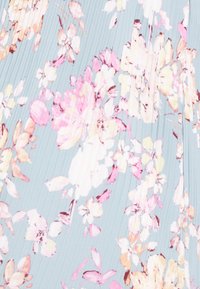 Tecido com padrão floral em azul claro, apresentando flores em rosa e branco. O material possui uma textura plissada, adicionando profundidade ao design.