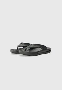Sandale negre cu talpă texturată, multiple perforații pe bretele și un design minimalist. Material din cauciuc pentru flexibilitate.