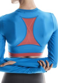 Blue athletic top with long sleeves, featuring a red mesh back insert and stitching accents. Material appears sleek and fitted.