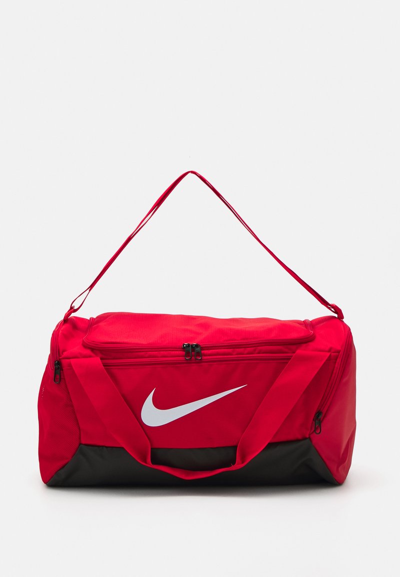Rød Nike duffel bag med en sort bund. Har et stort lynlåslomme, to håndtag og et fremtrædende hvidt logo på forsiden.