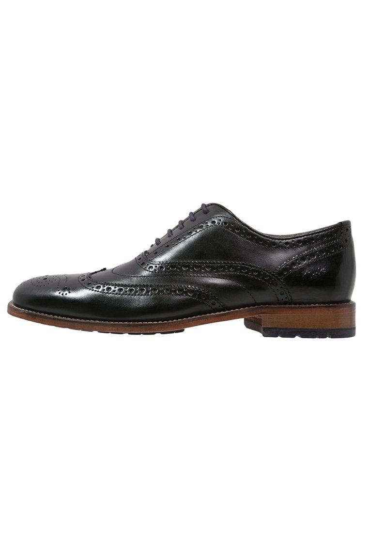 Chaussure brogue pour homme en cuir noir avec design en pointe d'aile, détails perforés, semelle marron et talon bas, présentée en profil latéral.