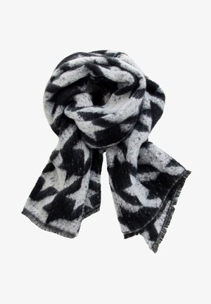 Écharpe en laine douce avec un motif abstrait noir et blanc, pliée de manière lâche avec les bords à franges visibles.