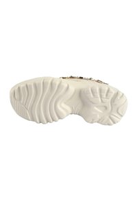 Fehér sneaker talp texturált mintákkal, kiemelkedő barázdákkal és hornyokkal. Aranylánc részlet az oldalán, amely hozzáad a dizájnhoz.