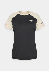 Kortærmet t-shirt med sort krop og beige ærmer. Har et logo på brystet og lyserøde detaljer på ærmerne. Fremstillet af åndbart materiale.
