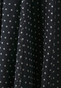 Sort stof med sølvprikker, der har en gennemsigtig, let tekstur. Prikkerne er jævnt fordelt over overfladen.