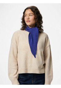 Blå tørklæde lavet af blødt stof, med en spids design, båret over en cremefarvet sweater. Tørklædet har en glat tekstur og falder elegant.