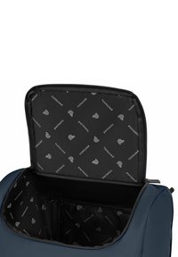 Borsa da viaggio blu navy aperta con fodera interna nera stampata con loghi "pactastic" e una tasca in rete all'interno.