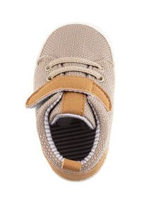 Beige fabric sneaker with brown leather strap, textured upper, round toe, and white rubber sole. Interior features black and white striped lining.