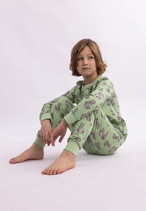 Grüne Baumwollpyjamas mit einem Muster von Kaninchen. Das Oberteil hat lange Ärmel, und die Hose hat elastische Bündchen.