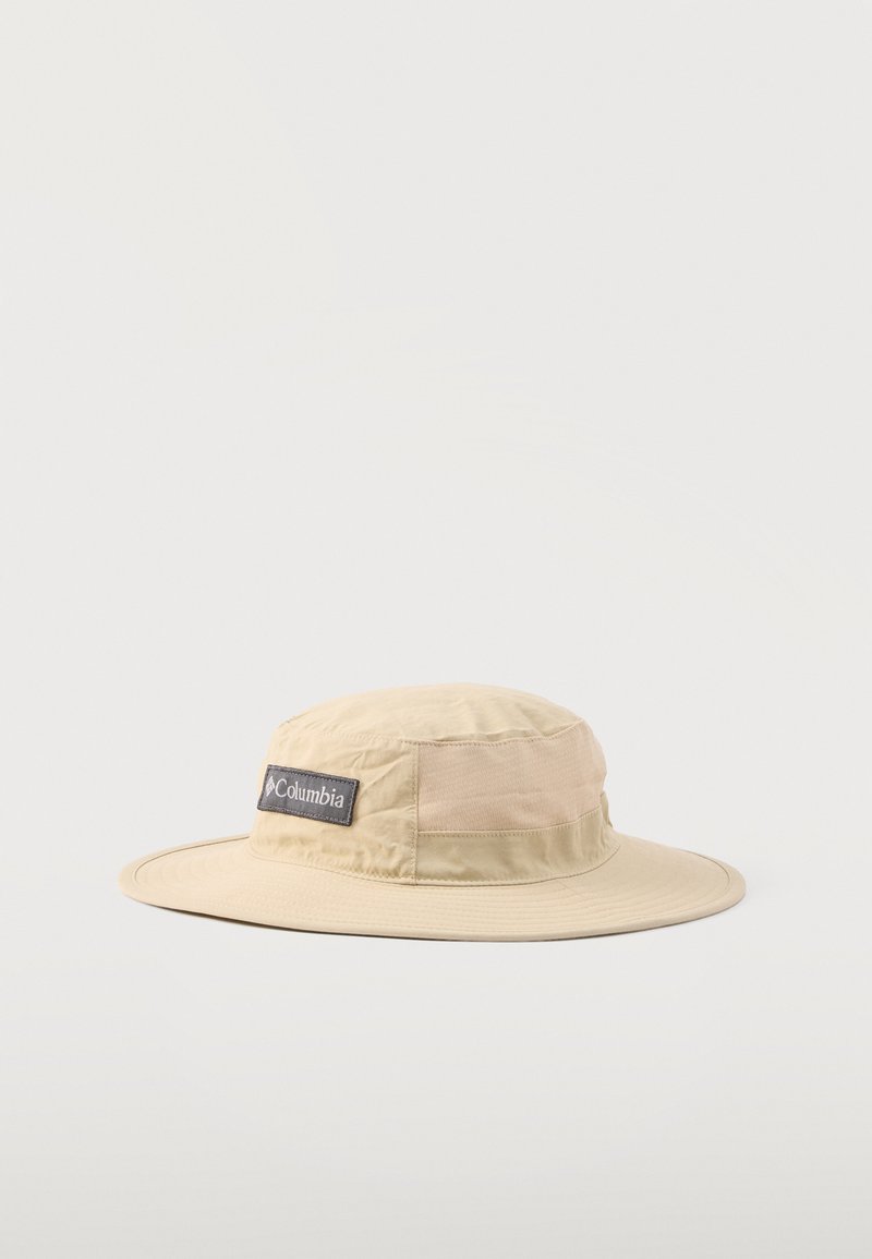 Sombrero de ala ancha para exteriores en beige claro con parche del logo de Columbia en el lateral, fabricado con tela suave para protección solar.