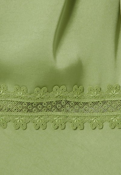 Tessuto di raso verde chiaro con una fascia orizzontale di pizzo floreale che presenta piccoli fiori e un motivo di rete intricata.
