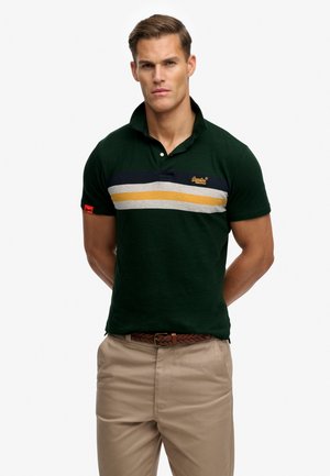 Grøn polo-shirt med korte ærmer, med blå, grå og gule vandrette striber. Logo på brystet og rød mærkat på ærmet.