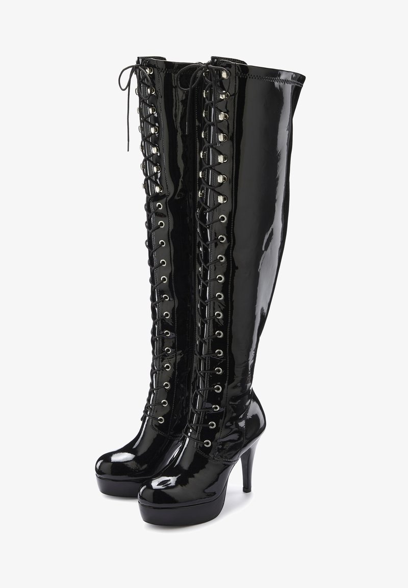 Stivali alti con tacco in pelle lucida nera con lacci frontali e occhielli argentati, caratterizzati da una suola a piattaforma per maggiore altezza.