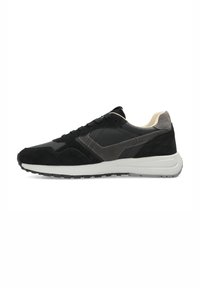 Scarpa sportiva nera in camoscio e pelle con accenti testurizzati, suola in gomma bianca e chiusura con lacci. Presenta un collare e una linguetta imbottiti.