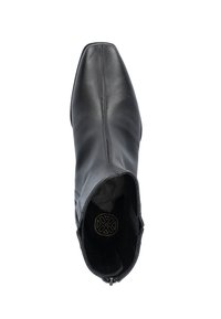 Bottines en cuir noir avec un bout pointu, texture lisse, talon plat et fermeture éclair sur le côté. L'intérieur présente un design de logo circulaire.