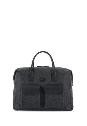 Sac de voyage en tissu gris foncé avec deux poches à rabat à l'avant, poignées en cuir noir et renforts aux coins, debout sur fond blanc.
