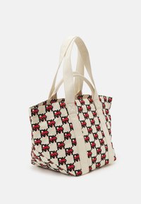 Sac fourre-tout en tissu beige avec un motif de logo répétitif noir et rouge. Il dispose de deux anses supérieures et d'un design spacieux et structuré.