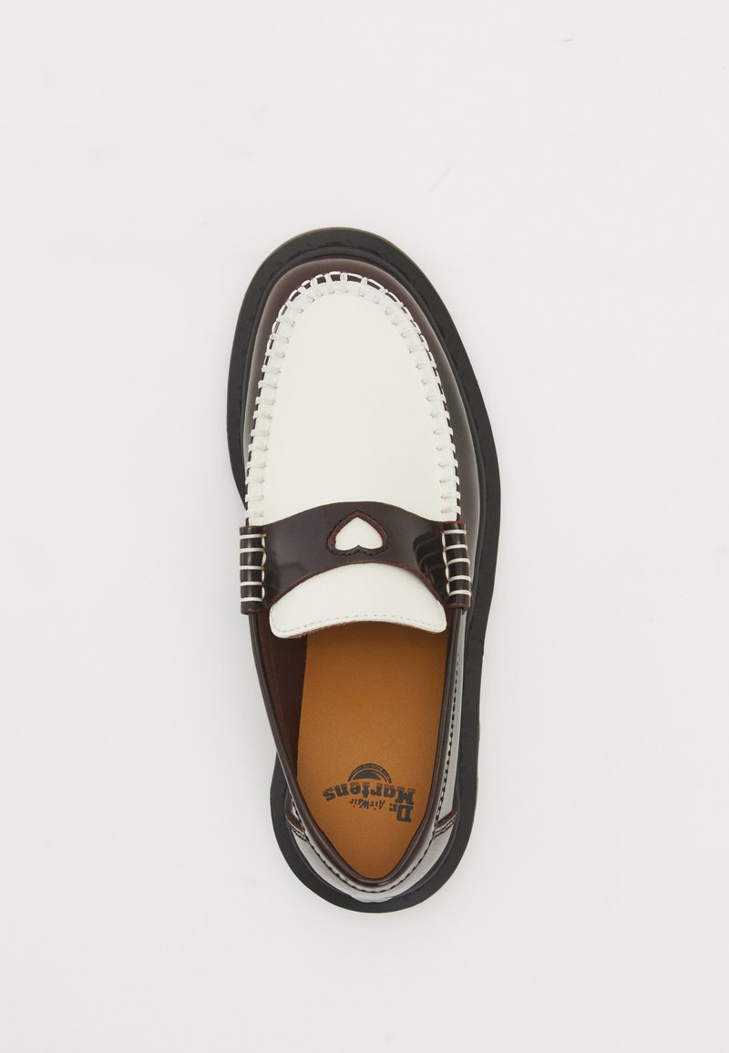 Mocassin bicolore marron et blanc avec une découpure en forme de cœur sur la bride, coutures visibles et semelle noire sur fond blanc.