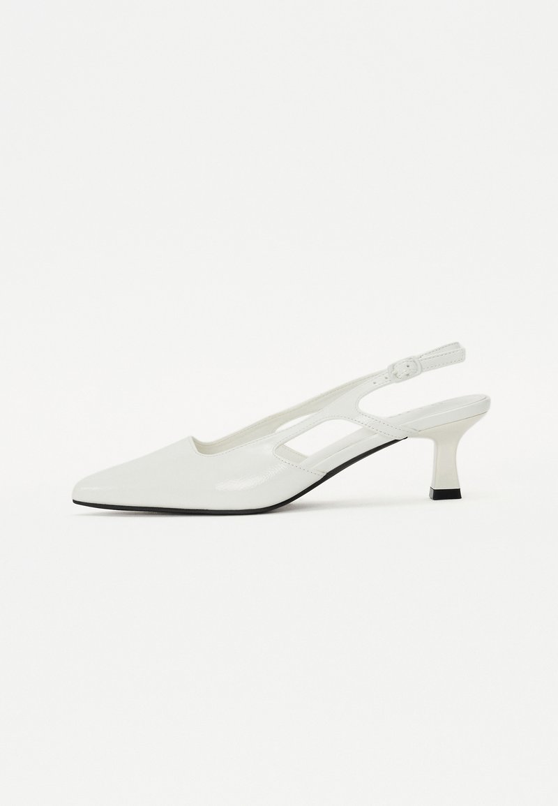 Chaussure slingback blanche en vernis avec un bout pointu, un talon bas et un design découpé. Dispose d'une sangle ajustable et d'un accent de semelle noire.