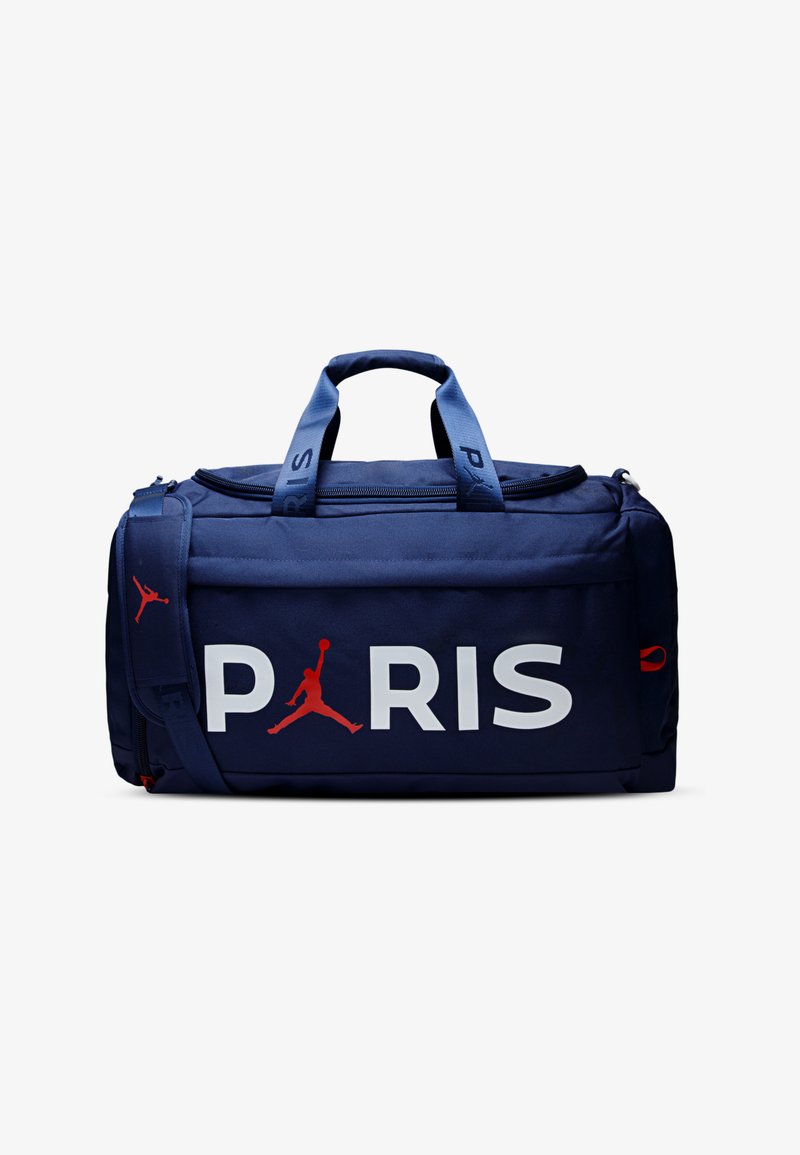 Bolsa marinera azul marino con "PARIS" en grandes letras blancas y logo rojo de Jordan. Cuenta con asas dobles y una correa ajustable para el hombro.