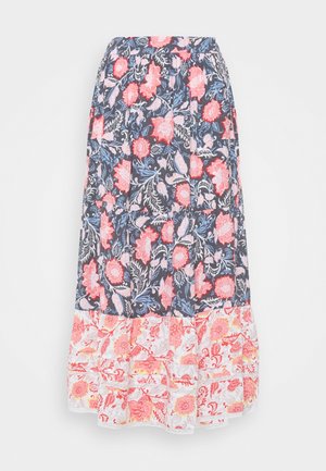 Jupe longue fleurie avec fond sombre et motifs de fleurs roses, bleues et blanches, présentant un ourlet volanté contrastant avec des fleurs rouges et jaunes.