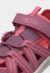 Παιδικό σανδάλι σε ροζ και μοβ χρώμα με ρυθμιζόμενο λουράκι και ελαστικά κορδόνια, με την επωνυμία "TROLLKIDS" στο λουράκι.