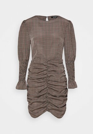 Langärmeliges Mini-Kleid mit Raffung, Hahnentrittmuster und Schlüssellochverschluss am Rücken, figurbetonte Silhouette mit gerafften Details.