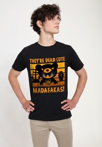 Czarny T-shirt z grafiką przedstawiającą niedźwiedzia, pomarańczowym napisem „SĄ MARTWO SŁODCY MADAFAKAS!” oraz elementami kreskówkowego nagrobka.