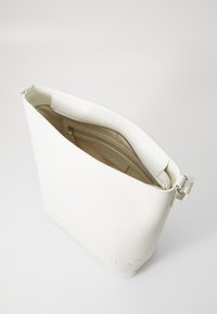 Borsa tote in pelle bianca con una trama liscia, dotata di chiusura con zip e di una tasca interna. Logo in rilievo discreto sul fronte.