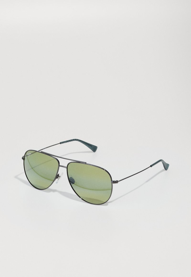 Metal aviator sunglasses with green tinted lenses; slim black frame; green rubber accents on temple tips; angular design.