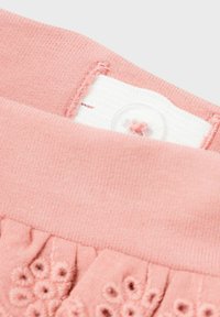 Leggings rosa con una texture morbida, dotati di chiusura a pulsante e adornati con motivi floreali ricamati vicino all'orlo. Design della vita liscia.