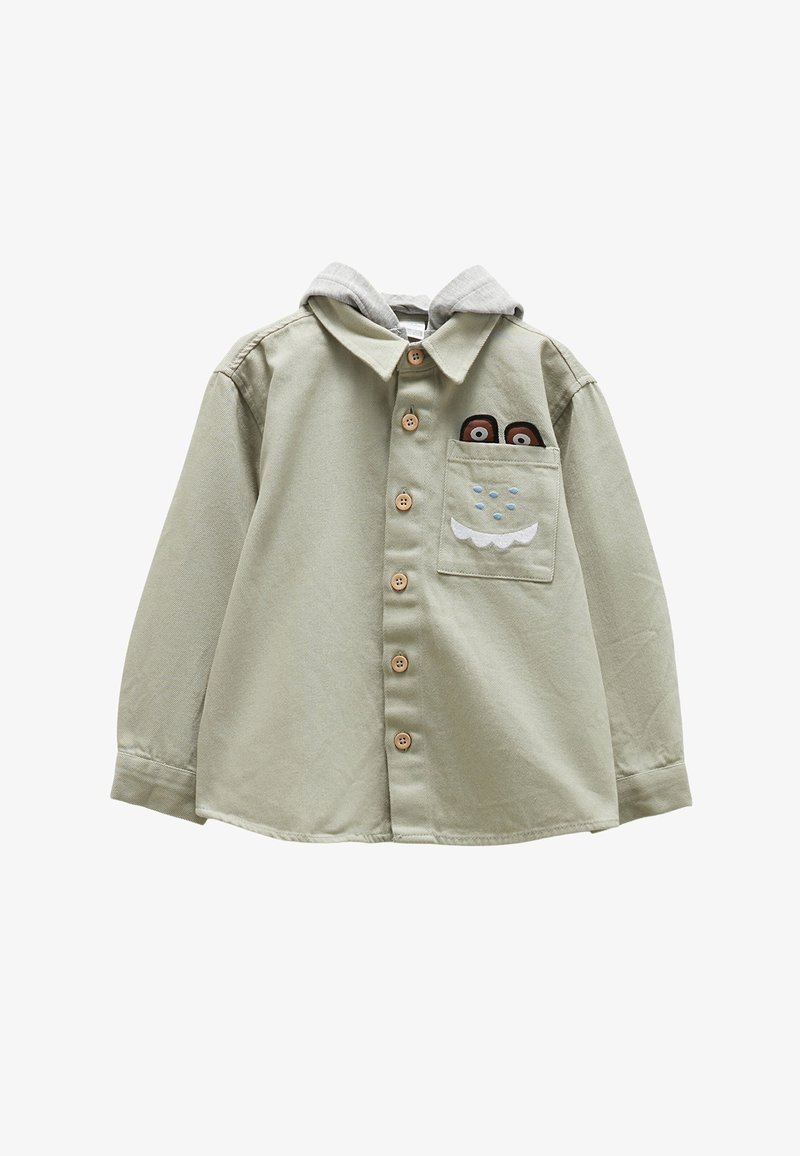 Světle zelená košile na knoflíky s šedou mikinou. Má dřevěné knoflíky a přední kapsu s vyšitými detaily postavy.
