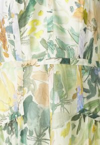Blumengemusterter Stoff in Pastellfarben, mit grünen Blättern und gelben Akzenten, weich und leicht im Griff sowie mit klaren Nähten.