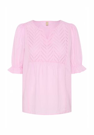 Svetlo roza bluzica iz bombaža, z V-izrezom, kratkimi napihnjenimi rokavi, vzorcem očes in nabranim pasom. Robovi rokavov so volančki.