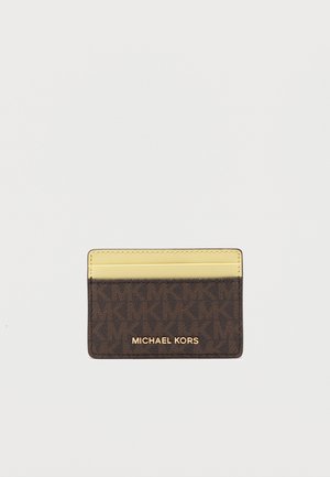 Kompakt kártyatartó barna Michael Kors monogrammal és sárga bőrből készült felső résszel, három kártyafoglalattal.