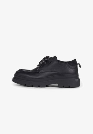 Zwarte leren veterschoen met dikke, robuuste zool en ronde neus, met een trekriem aan de hiel en veters met een contrasterend patroon.