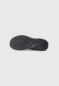 Schwarze Schuhsohle mit strukturiertem Profilmuster und Puma-Logo an der Ferse, auf einem schlichten weißen Hintergrund präsentiert.