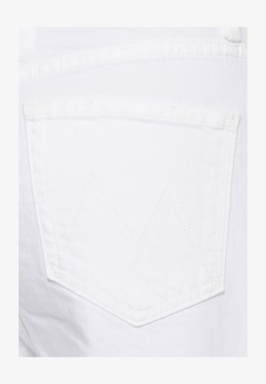 Tasca posteriore di jeans in denim bianco con un sottile dettaglio di cucitura a zigzag.