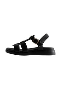 Svart sandal med flera remmar, spänne, platt sula, tillverkad av syntetmaterial, med en slät yta.